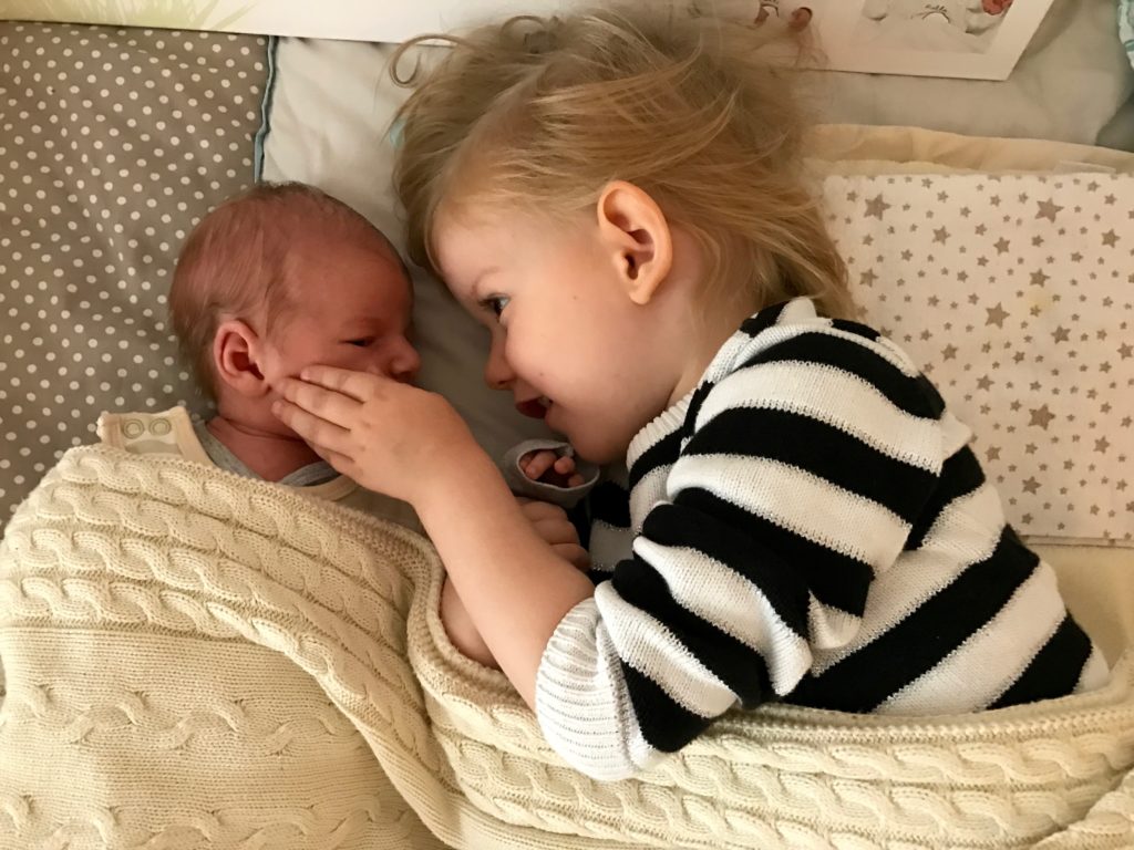 grosse Schwester trifft kleinen Bruder zum ersten Mal